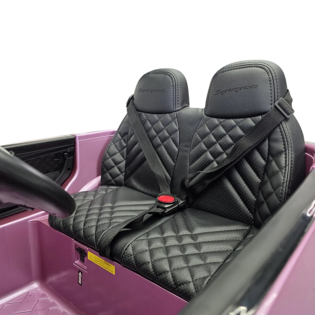 Siège en cuir noir matelassé avec ceintures de sécurité dans la voiture électrique enfant Odecare Bentley rose