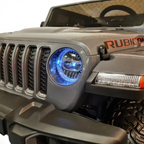 Gros plan sur la calandre et le phare LED bleu d'une Jeep électrique enfant Petit Pilote Gladiator grise