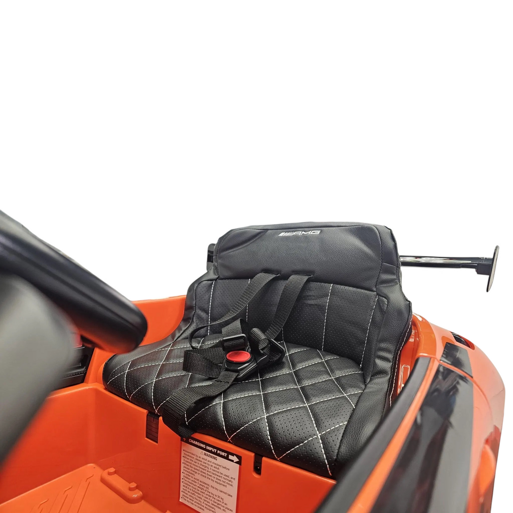 Siège en cuir noir matelassé avec ceinture de sécurité dans la voiture électrique Petit Pilote Mercedes AMG GT3 orange