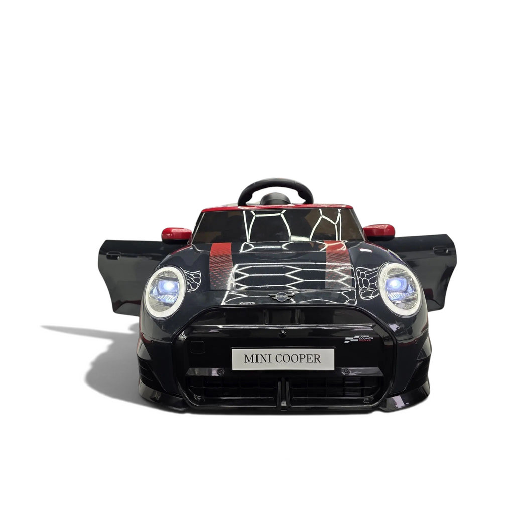 Voiture électrique enfant Petit Pilote Mini Cooper S noire métallisée avec phares LED allumés dans un showroom