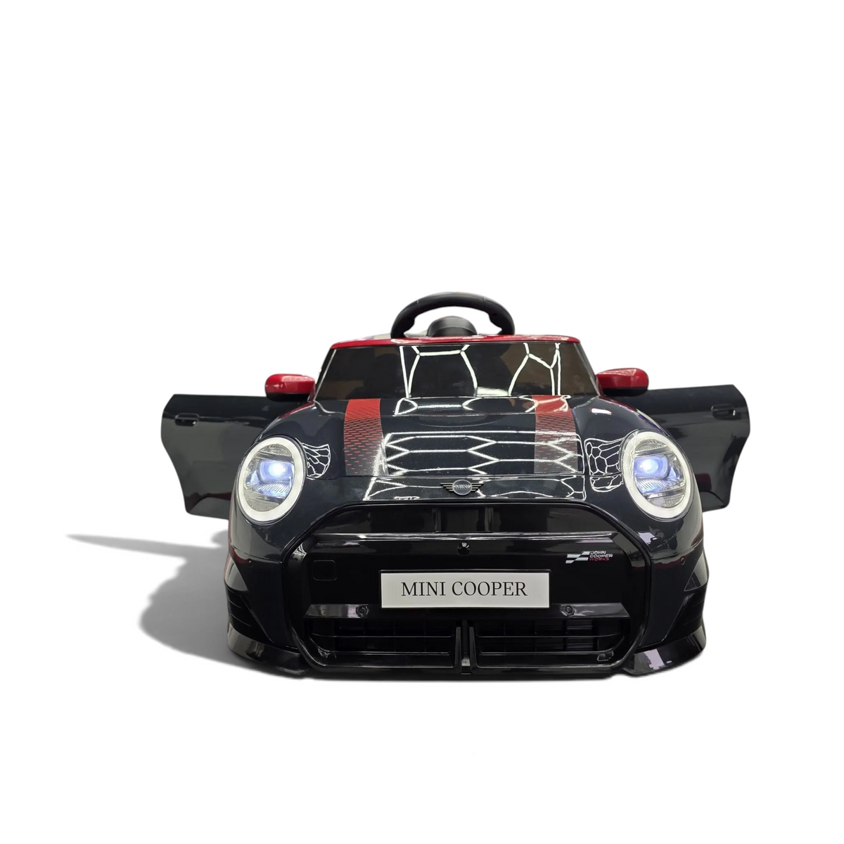 Voiture électrique enfant Petit Pilote Mini Cooper S noire métallisée avec phares LED allumés dans un showroom