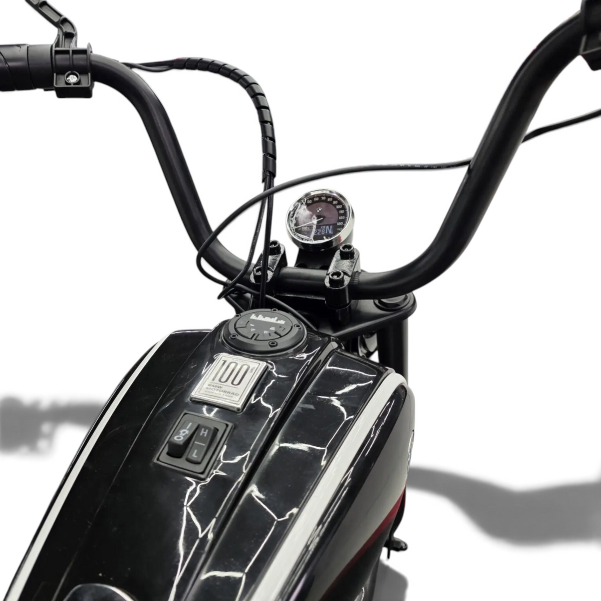 Vue rapprochée du guidon et du réservoir noir de la moto électrique enfant Petit Pilote BMW R18 24V avec compteur