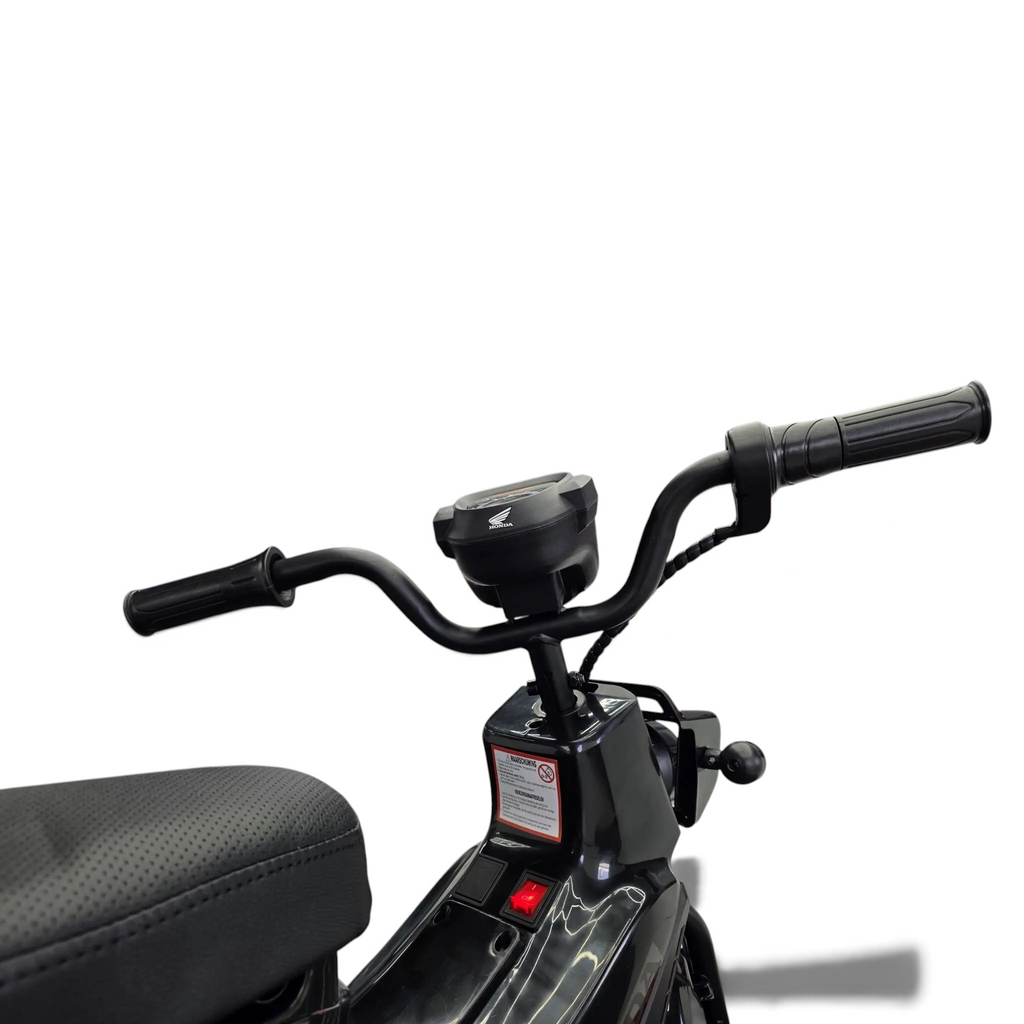 Vue rapprochée du guidon de la moto électrique enfant Petit Pilote Honda Cross Cub 110 noire avec détails du tableau de bord