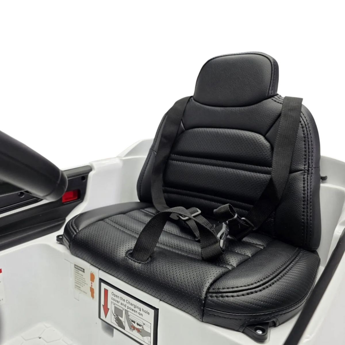 Siège en cuir noir avec ceinture de sécurité dans la voiture électrique enfant Petit Pilote Porsche Cayenne blanche
