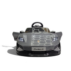 Voiture électrique pour enfant Petit Pilote Porsche Taycan grise avec portes ouvrantes et phares LED dans un showroom