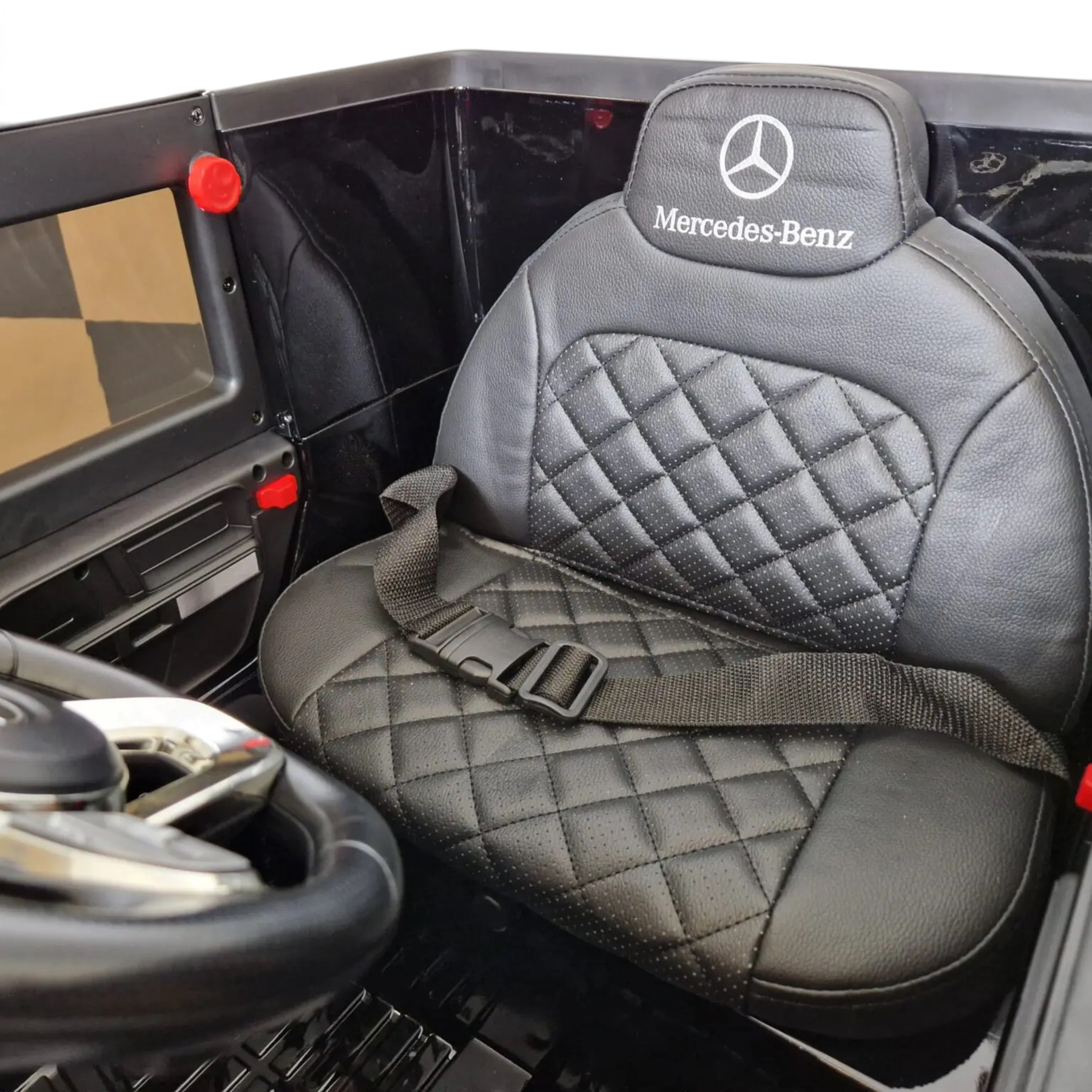 Siège en cuir noir matelassé avec logo Mercedes-Benz et ceinture de sécurité dans la voiture électrique Petit Pilote