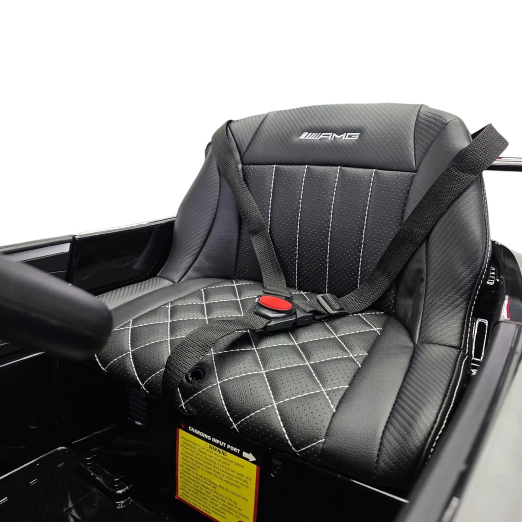 Siège en cuir noir matelassé avec logo AMG et ceinture de sécurité dans une voiture électrique enfant Petit Pilote