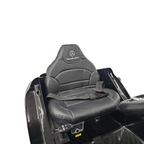 Siège en cuir noir avec logo Mercedes-Benz pour voiture électrique enfant Petit Pilote, incluant une ceinture de sécurité.