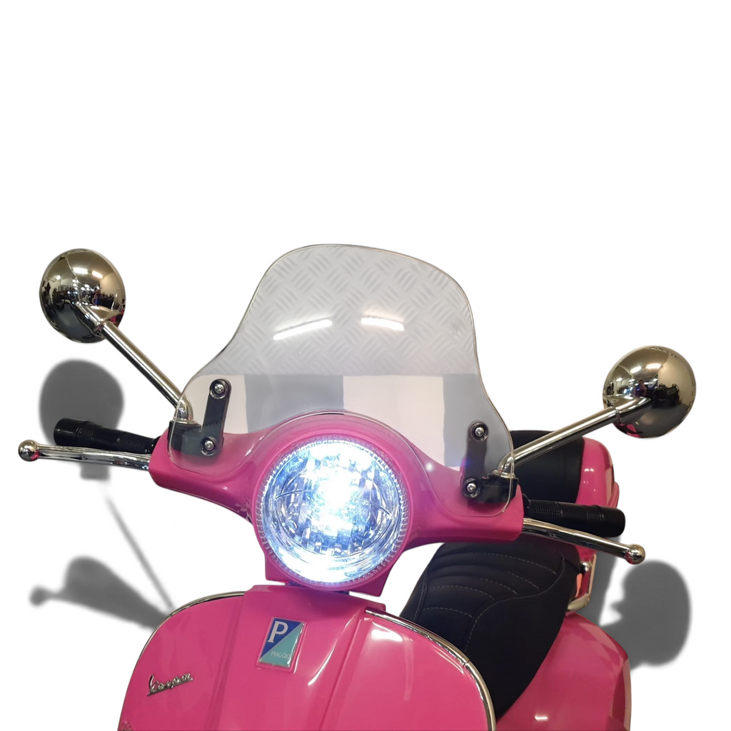 Vue rapprochée du guidon de la Vespa GTS rose Petit Pilote pour enfant avec phare LED allumé, pare-brise et rétroviseurs