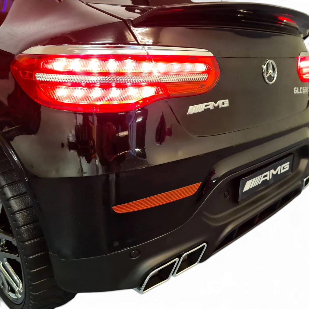 Vue arrière de la voiture électrique enfant Petit Pilote Mercedes GLC 63 AMG noire métallisée avec feux LED allumés