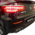 Vue arrière de la voiture électrique enfant Petit Pilote Mercedes GLC 63 AMG noire métallisée avec feux LED allumés