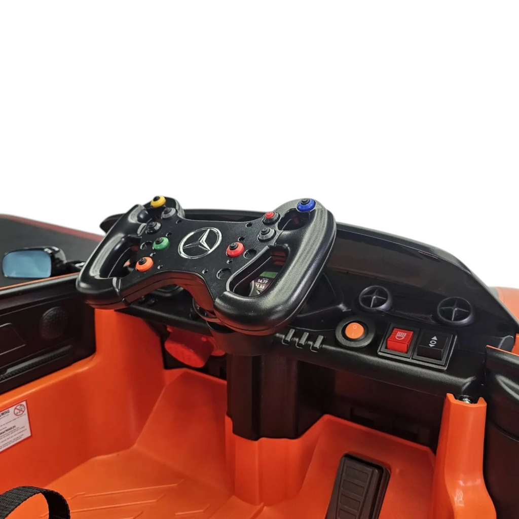 Intérieur de la voiture électrique enfant Petit Pilote Mercedes AMG GT3 orange avec volant sport et tableau de bord