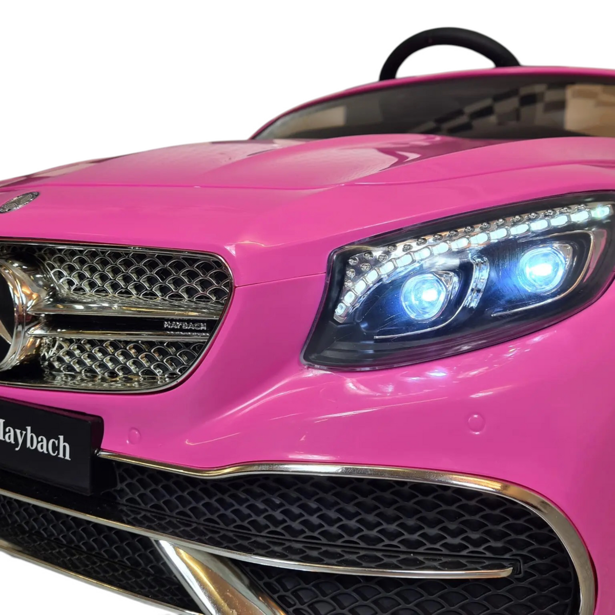 Gros plan sur la calandre et les phares LED d'une voiture électrique enfant Petit Pilote Mercedes S650 rose