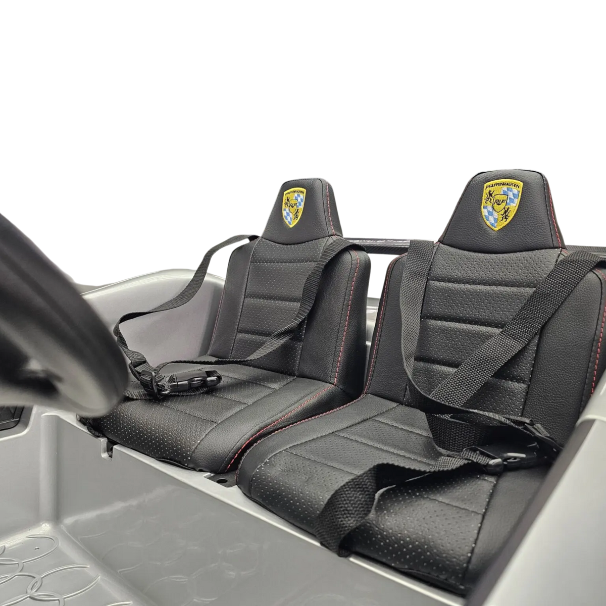 Intérieur de la voiture électrique enfant Petit Pilote Porsche RUF 24V avec deux sièges en cuir noir et ceintures de sécurité