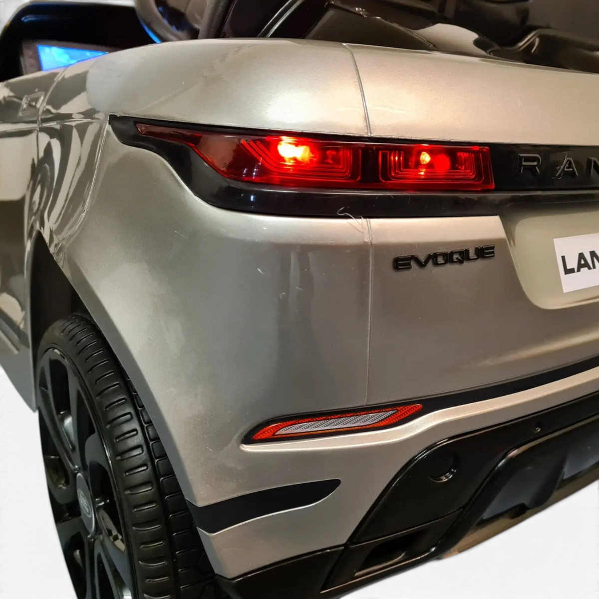 Vue arrière de la voiture électrique pour enfant Odecare Range Rover Evoque gris métallisé avec feux rouges allumés