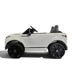 Voiture électrique enfant Petit Pilote Range Rover Evoque blanche avec pneus caoutchouc et siège en cuir dans un showroom