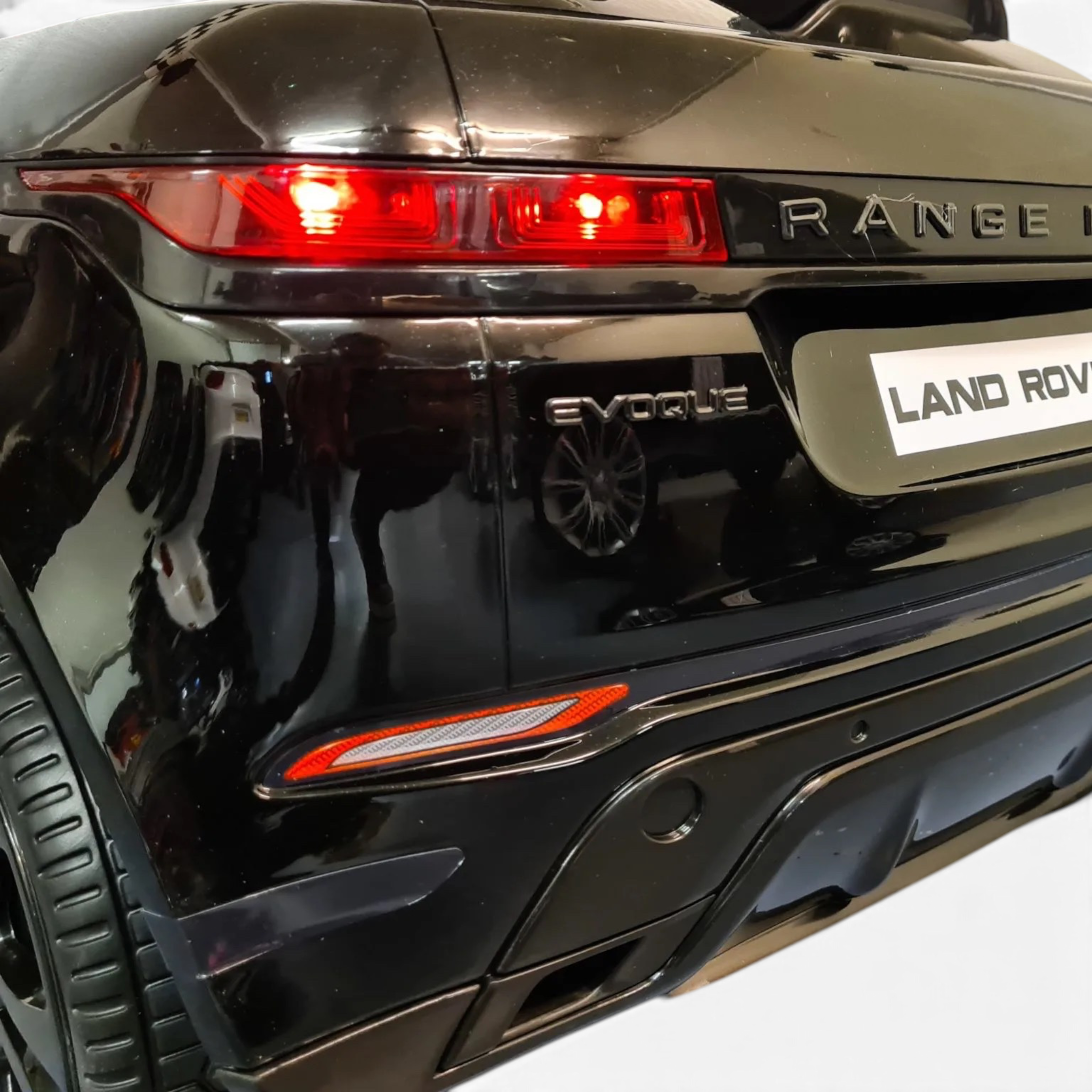 Vue arrière de la voiture électrique enfant Petit Pilote Range Rover Evoque 4x4 noir métallisé avec feux rouges allumés