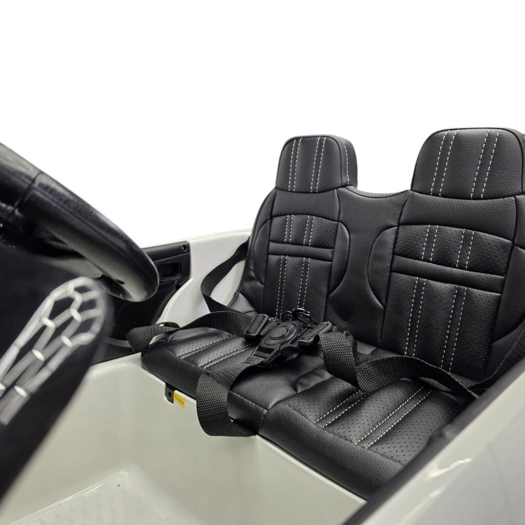 Siège en cuir noir avec harnais de sécurité dans la voiture électrique enfant Petit Pilote Range Rover Evoque blanche