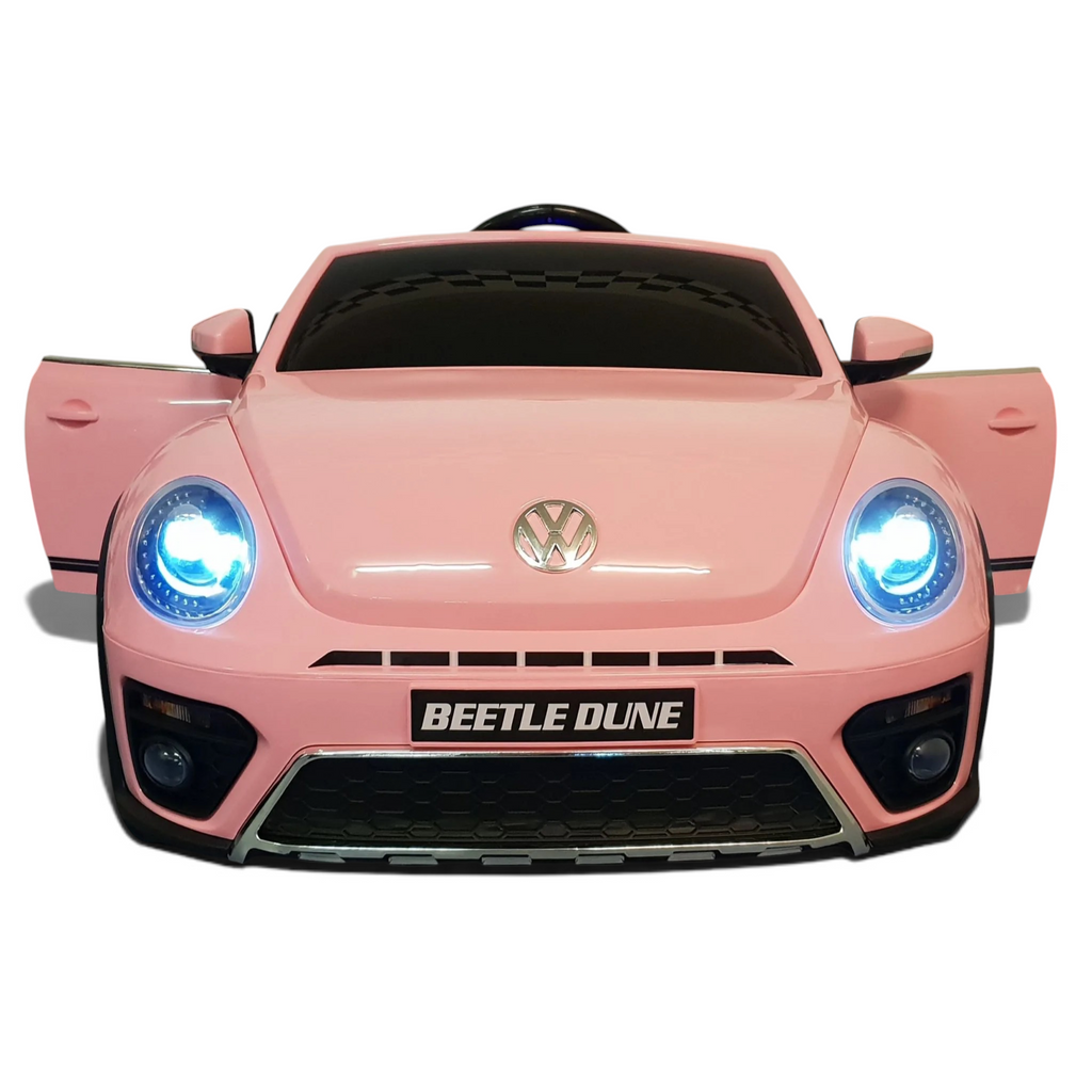 Voiture électrique enfant Petit Pilote VW Beetle rose avec phares LED allumés, vue de face, style rétro-chic.