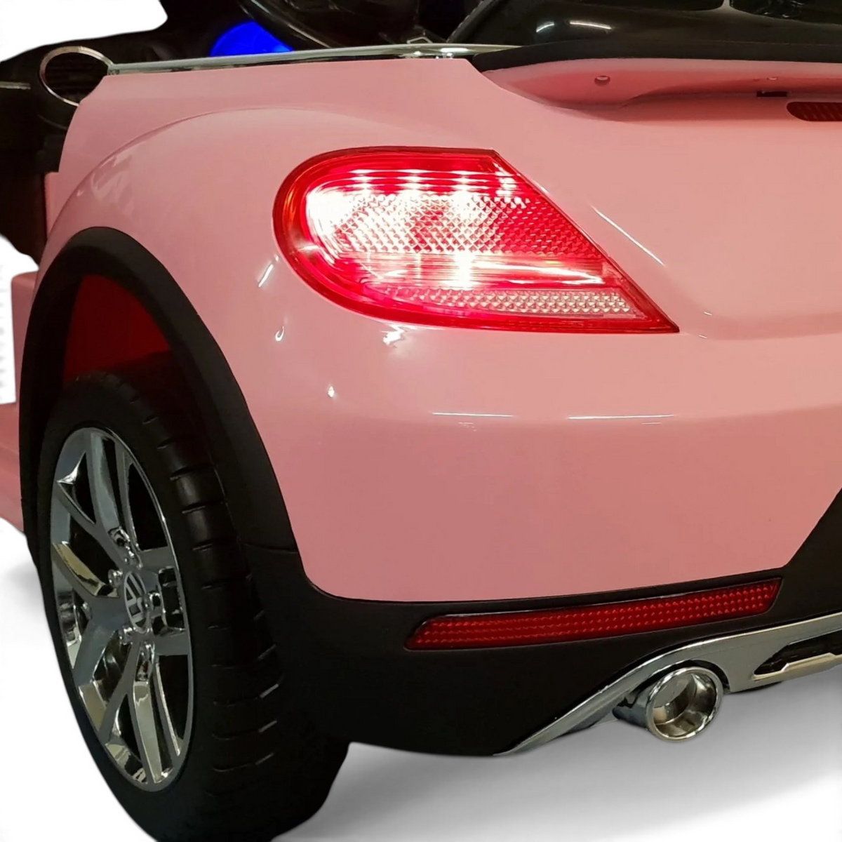 Vue arrière de la voiture électrique pour enfant Odecare VW Beetle rose avec feux LED allumés et détails chromés