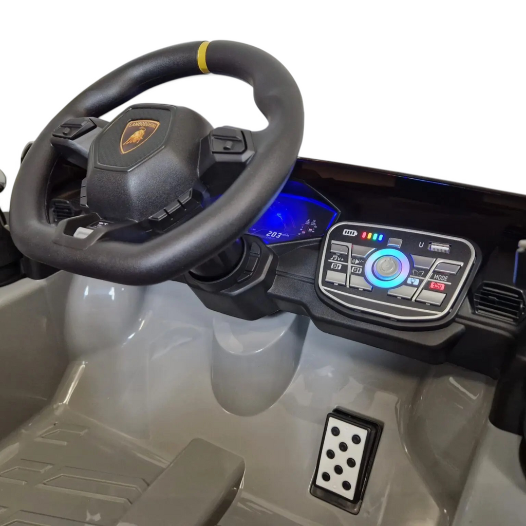 Intérieur de la voiture électrique Petit Pilote Lamborghini Huracán STO grise avec volant, tableau de bord et pédale