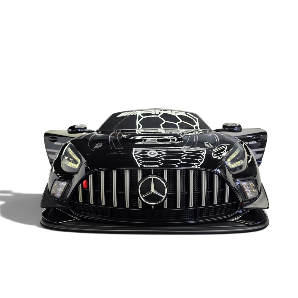Voiture électrique enfant Petit Pilote Mercedes AMG GT3 noire métallisée avec phares LED dans un showroom