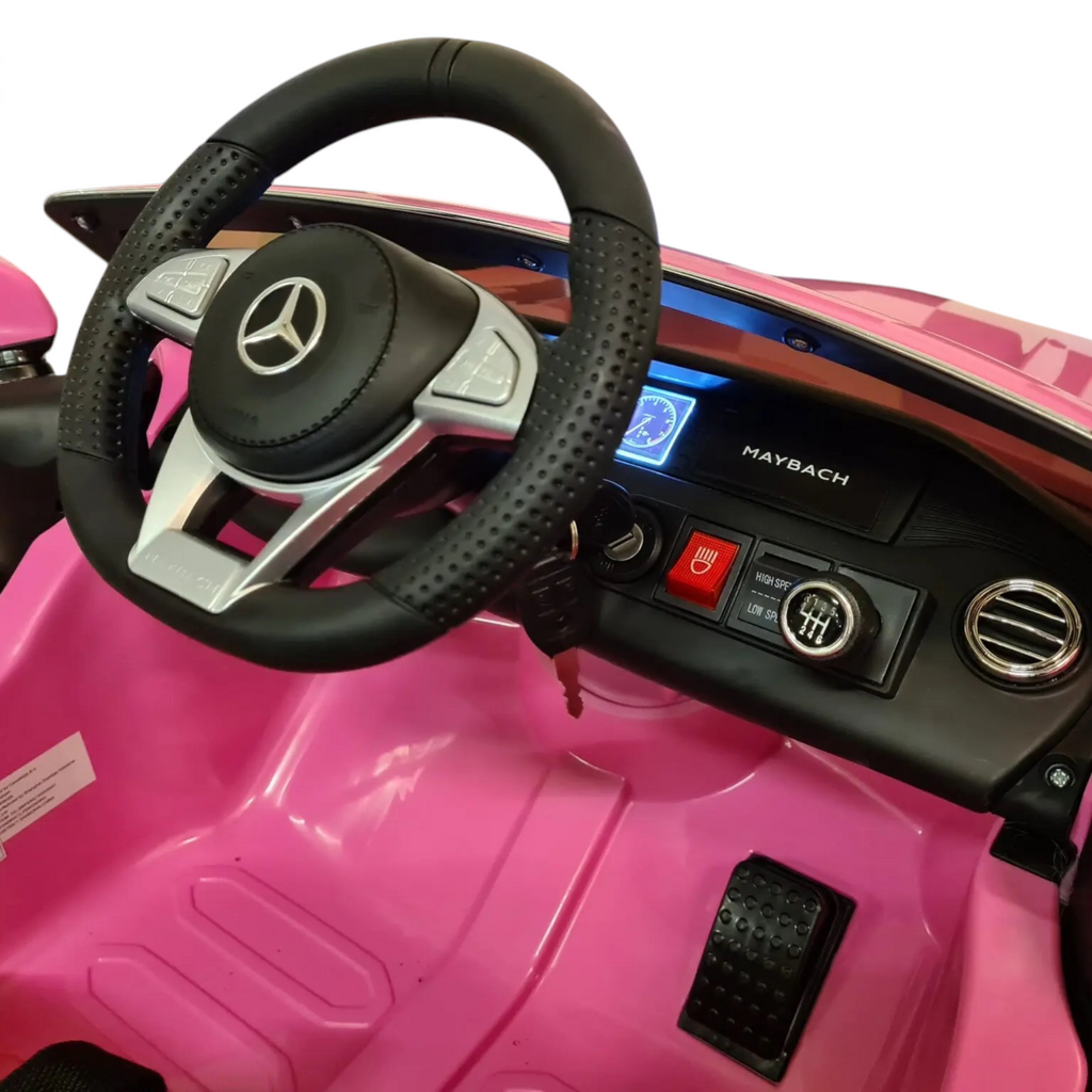 Vue intérieure du poste de pilotage de la voiture électrique Petit Pilote Mercedes S650 rose avec volant et tableau de bord