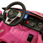 Vue intérieure du poste de pilotage de la voiture électrique Petit Pilote Mercedes S650 rose avec volant et tableau de bord