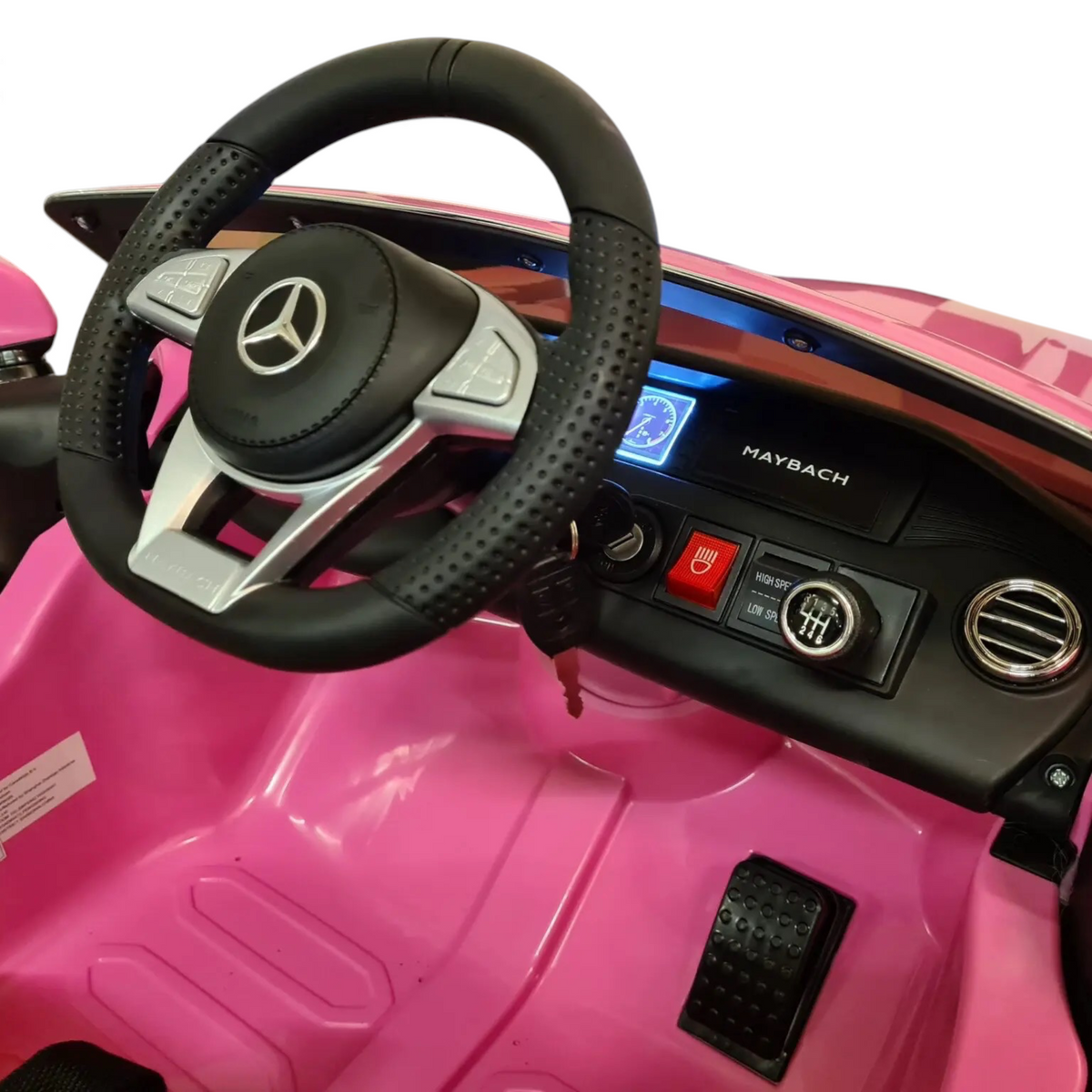 Vue intérieure du poste de pilotage de la voiture électrique Petit Pilote Mercedes S650 rose avec volant et tableau de bord