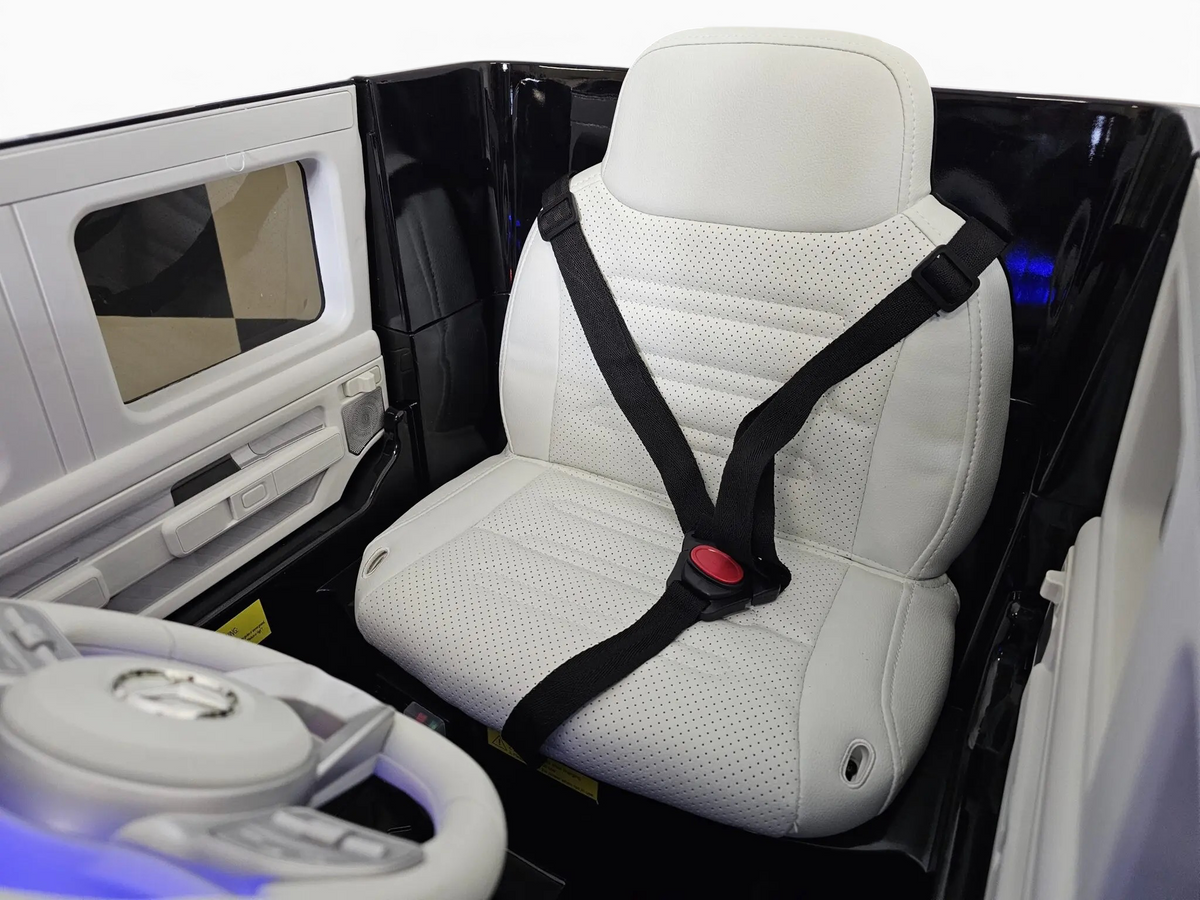 Siège en cuir blanc perforé avec ceinture de sécurité dans la voiture électrique pour enfant Odecare Mercedes EQG