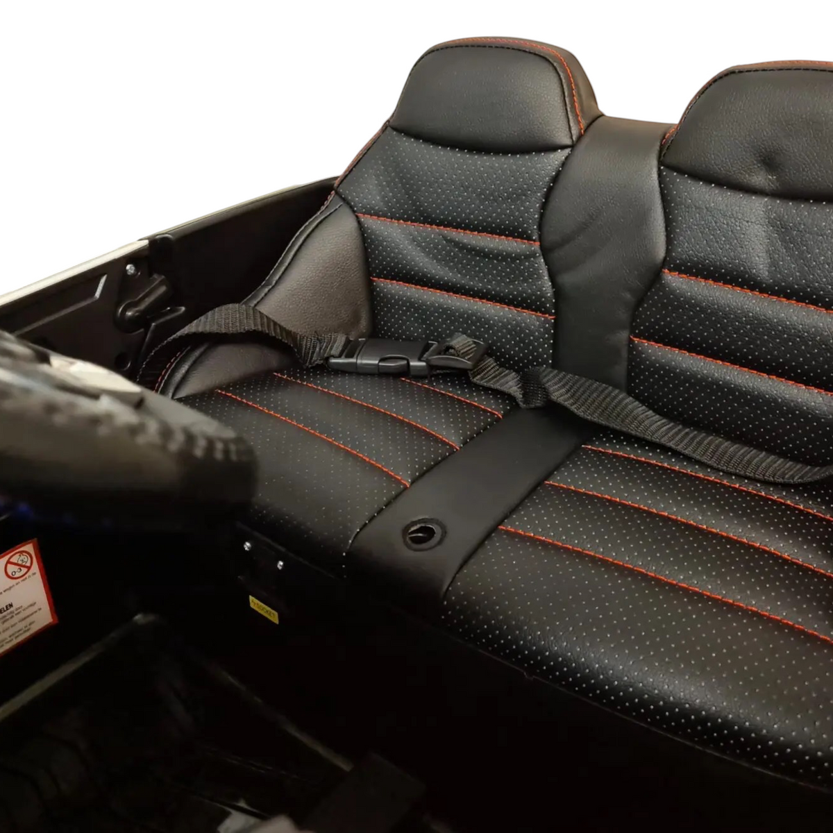 Siège en simili cuir noir avec surpiqûres rouges et ceinture de sécurité dans la voiture de police Petit Pilote pour enfant